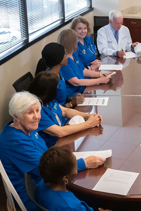 Doctor and staff meeting around table